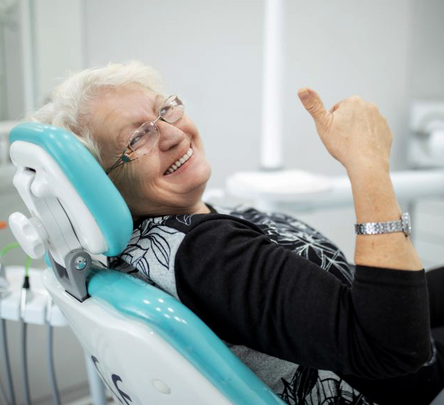 Senior woman smiling in dental chair at Austin Park Dental office during appointment.
