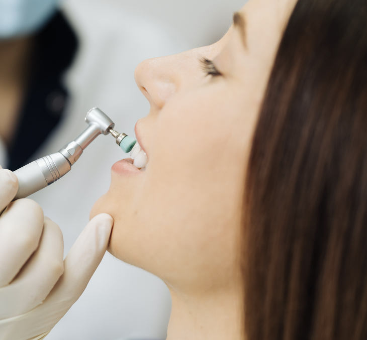 Woman receiving dental injection from gloved dentist hand at dental clinic.